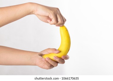 Hands hold and peel banana isolated on white background.