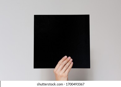 Hands hold a  sheet. Empty space for the label.