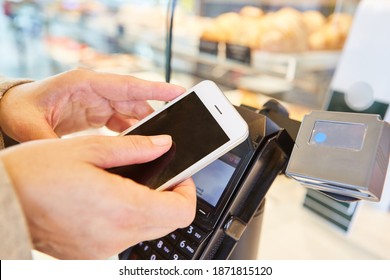 Hands Hold Smartphone With App For Contactless Payment At The Supermarket Checkout
