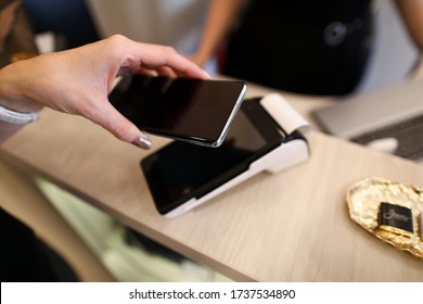 Hands Hold Smartphone For Contactless Payment. Payment Services Are Also Responsible For Security Cash Transactions. Payment By Electronic Money. Employee Store Uses Banking Acquiring