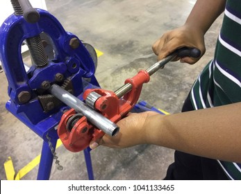 Hands Hold Or Using Steel Pipe Cutter Tool For Fast And Clean Pipe Cutting. Industrial Skill.