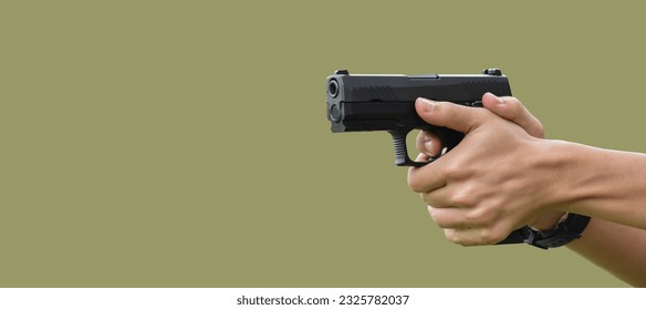 Hands holding 9mm pistol gun isolated on green background with clipping paths.