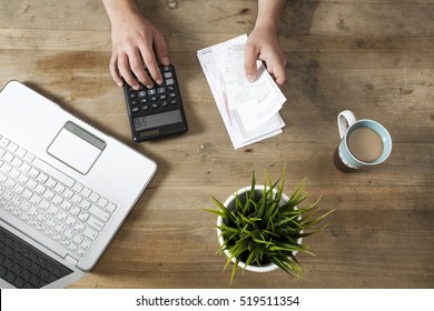 Hands Holding Bills And Paying Bills On Computer