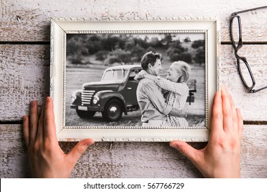 Hands Holding Black-and-white Photo Of Seniors In Picture Frame