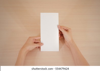 Hands Holding Blank White Brochure Booklet In The Hand. Leaflet Presentation. Pamphlet Hand Man. Show Offset Paper. Sheet Template. Book In Hands. Booklet Folding Design. Fold Paper Sheet Display Read