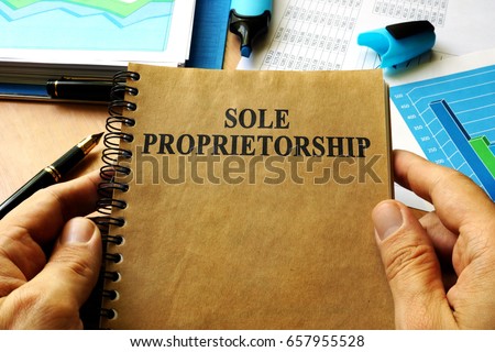Hands holding book with title Sole proprietorship.