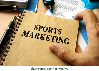 Hands Holding Book With Title Sports Marketing.