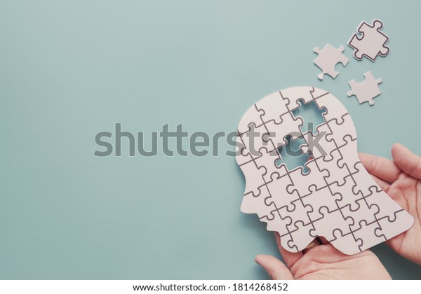 Hands holding brain with\
puzzle paper cutout, autism, memory loss, dementia, epilepsy and\
alzheimer awareness, world mental health day, world Parkinson day\
concept
