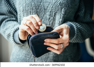 Hands Holding British Pound Coin And Small Money Pouch