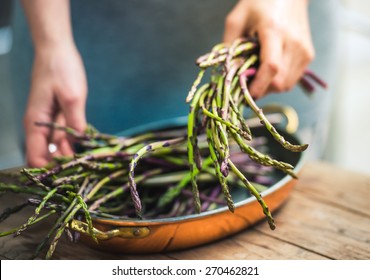Hands holding a bunch of fresh asparagus. Selected focus and shallow DOF