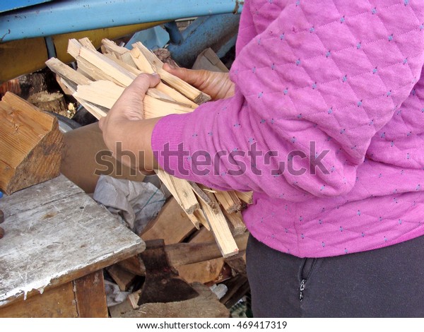 Hands holding the bunch of kindling splints\
close up.                               \
