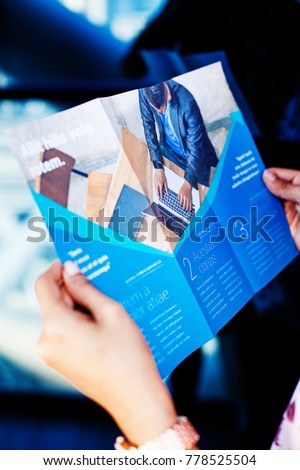 Hands holding a business brochure