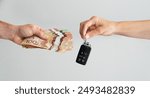 Hands holding car key and cash, Selling or Buying Car Concept