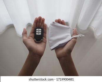 Hands Holding A Car Key And A Face Mask.