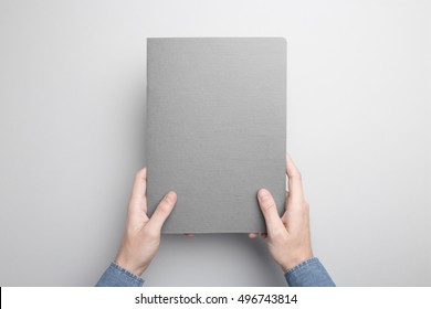 Hands Holding Closed Notebook. Blank Cover Mock-up.