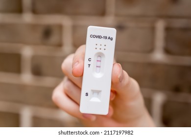 Hands Holding Covid-19 Rapid Antigen Test Cassette With Positive Result Of Rapid Diagnostic Test At Home