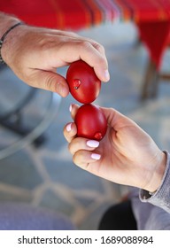 Hands Holding Cracked Red Easter Eggs - Orthodox Greek Tradition Of Cracking Eggs - Symbolizes Christ Resurrection