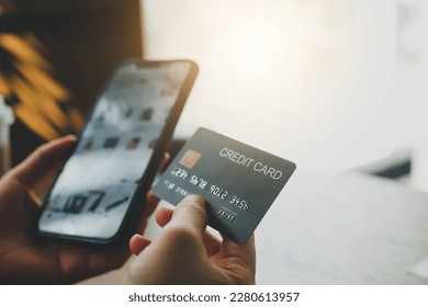 Hands holding credit card and using phone for online shopping - Powered by Shutterstock