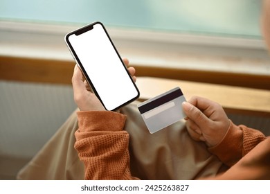 Hands holding credit card and using smartphone shopping online or transferring money in ebank app - Powered by Shutterstock