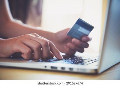 Hände, die Kreditkarte und Laptop benutzen. Online-Shopping