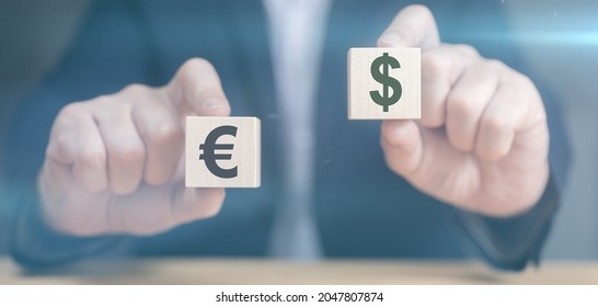 Hands holding cubes with dollar and euro icon. Currency concept. businessman's hands hold two wooden cubes with dollar and euro sign. businessman chooses euro or dollar signs