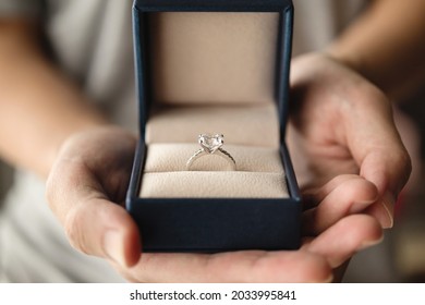 Hands Holding Diamond Ring In Jewelry Box