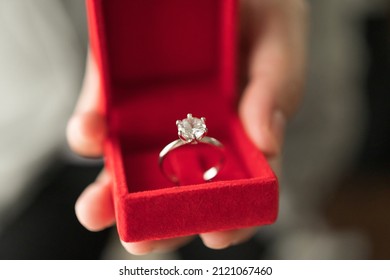 Hands Holding Diamond Ring In Jewelry Box