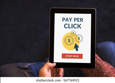 Hands holding digital tablet computer with Pay Per Click (PPC) concept on screen. All screen content is designed by me. View from above.