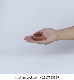 Hands Holding Dirty Dentures. Denture