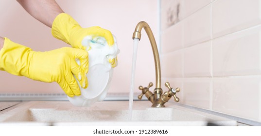 Hands Holding Dirty Dish And Wash It In The Kitchen Sink Pouring Water
