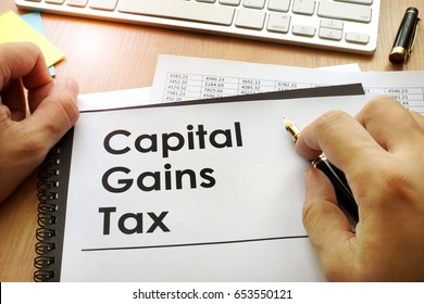 Hands holding documents with title capital gains tax CGT. - Shutterstock ID 653550121