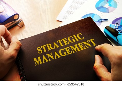 Hands holding documents with title Strategic management.