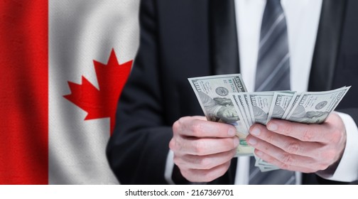 Hands Holding Dollar Money On Flag Of Canada