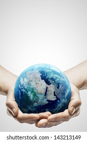 Hands Holding Earth On Gray Background