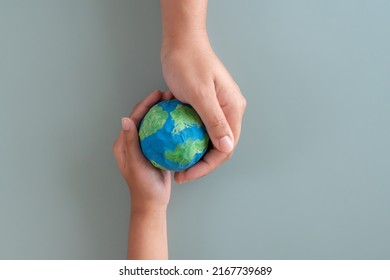Hands holding earth paper and water paint. Concept of protecting the world from global warming. Sustainability topic to save the world.