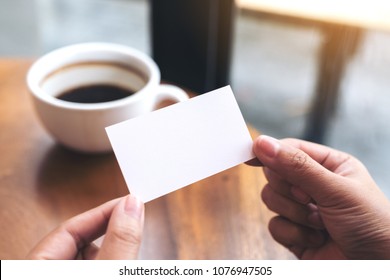 Hands Holding An Empty Business Card With Coffee Cup On Table