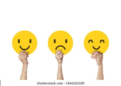 Hands holding face emotions in sadness and happiness isolated on white background.