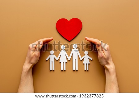 Hands holding family figure. Life and health insurance concept.