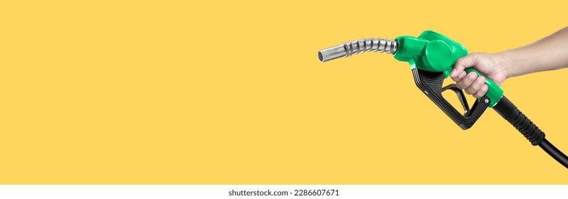 Hands holding Fuel nozzle on yellow background