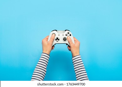 Hands holding a gamepad on a blue background. Banner. Concept games, video games - Powered by Shutterstock