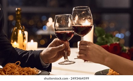 Hands holding glasses of wine on restaurant background. Let's have a toast concept - Powered by Shutterstock