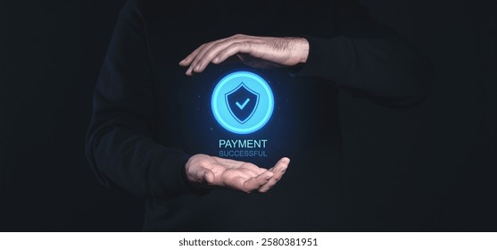Hands holding a glowing secure shield icon with Payment Successful text on a dark background. Concept of secure online transactions - Powered by Shutterstock - Get 15% off with code: PIKWIZARD15