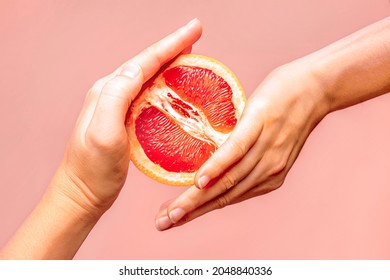 Hands holding grapefruit. Symbol of vagina. Female health, sex, menstruation concept