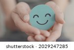 Hands holding green happy smile face, good feedback rating and positive customer review,experience, satisfaction survey,mental health assessment,child feeling good,world mental health day, Compliment 