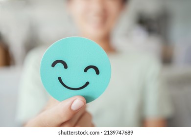 Hands holding green happy smile face paper cut, good feedback rating,think positive, customer review, assessment, child wellness,world mental health day, Compliment Day - Shutterstock ID 2139747689
