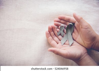 hands holding grey ribbons, Brain cancer awareness, Brain Tumors,Asthma awareness, Allergies and Diabetes awareness