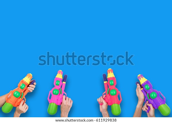 Hands holding\
gun water toy on blue\
background.