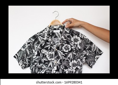 Hands Holding  Hawaiian Shirt  Is Clothes Hanger On White Background.