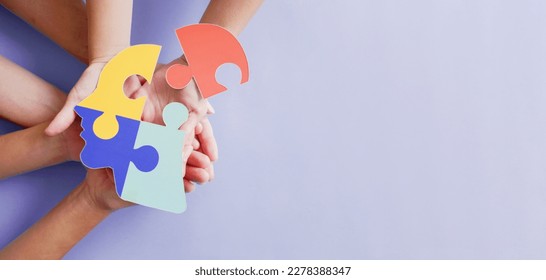 Hands holding jigsaw puzzle head shape, Autism awareness, Autism spectrum disorder (ASD), World Autism Awareness Day - Powered by Shutterstock