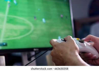 Hands Holding a Joystick Controller while playing a video games at home